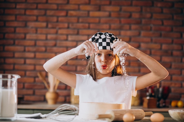 Niña pequeña hornear pasteles en la cocina para el desayuno