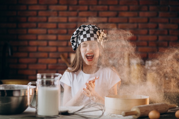 Niña pequeña hornear pasteles en la cocina para el desayuno