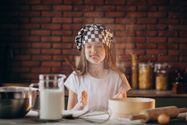 Niña pequeña hornear pasteles en la cocina para el desayuno