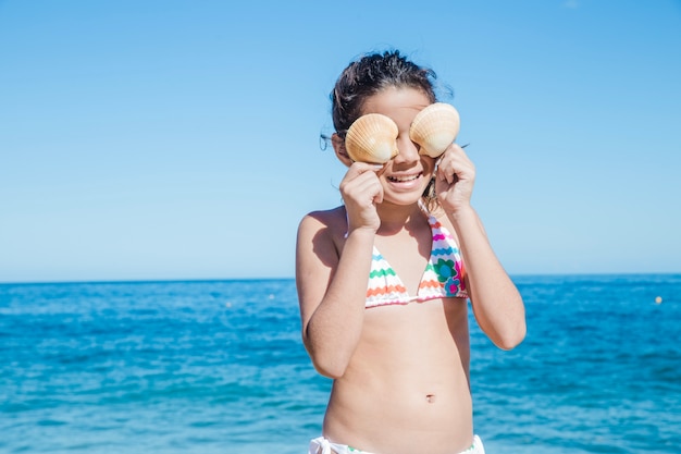 Niña pequeña jugando con conchas