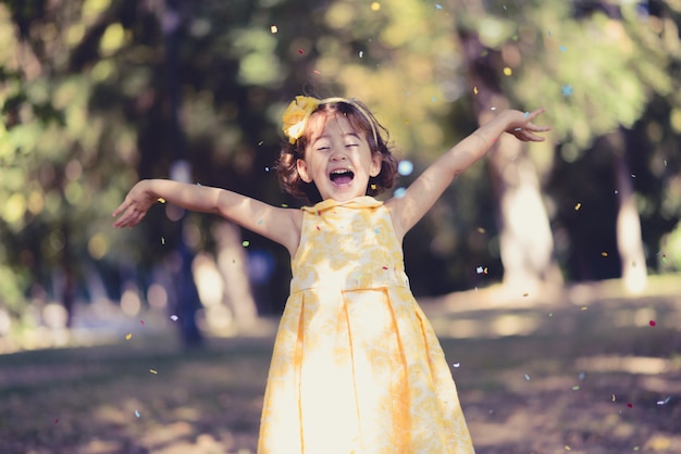 Niña pequeña lanzando confeti al aire