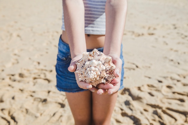 Niña pequeña ofreciendo una caracola