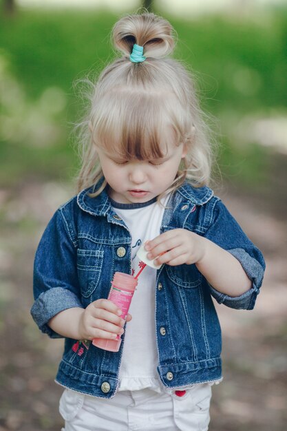 Niña pequeña en un parque con un pompero