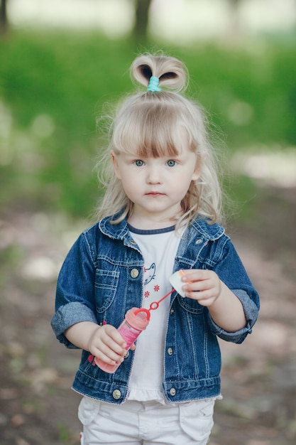 Niña pequeña en un parque con un pompero