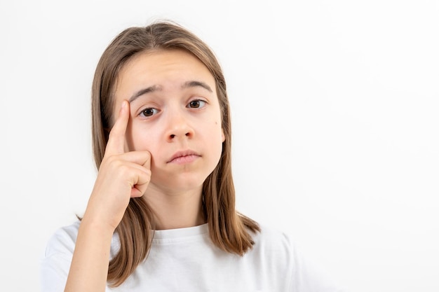 Foto gratuita niña pequeña pensando sosteniendo el dedo en el templo aislado en fondo blanco