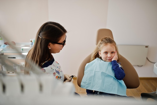 Niña pequeña en la silla del dentista