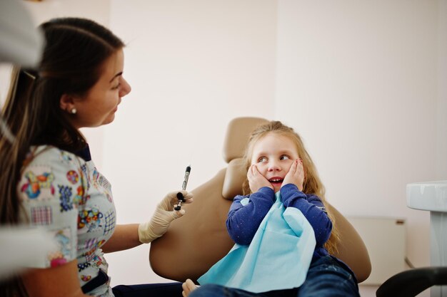 Niña pequeña en la silla del dentista