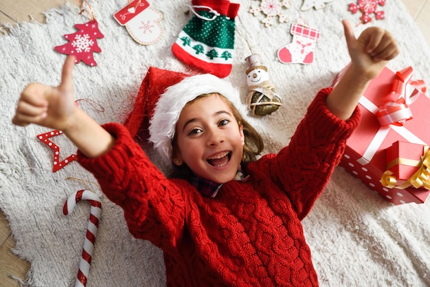 Foto gratuita niña pequeña sonriente vistiendo el sombrero de papa noel