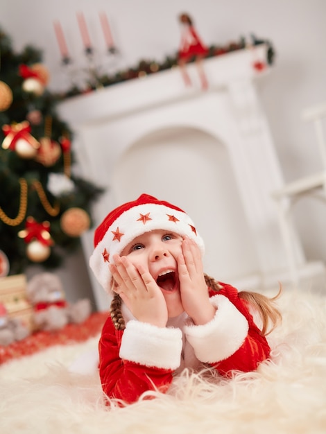 Niña pequeña vestida de papa noel sorprendida