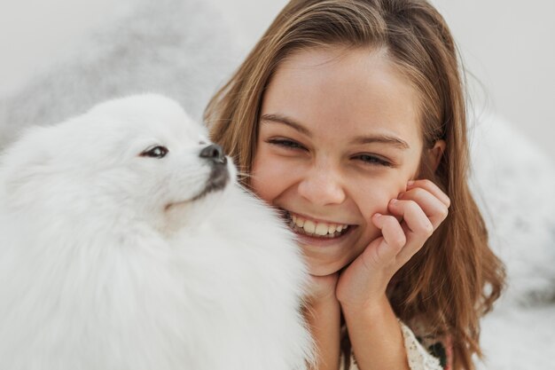 Niña y perro felices y jugando.