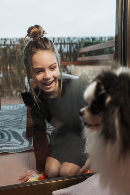 Foto gratuita niña y perro mullido jugando