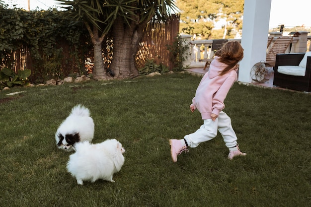 Niña y perros corriendo y jugando.