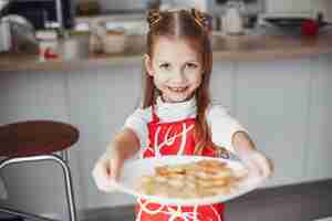 Foto gratuita niña de pie en una cocina con galletas