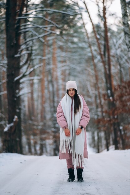 Niña de pie en medio de la carretera nevada