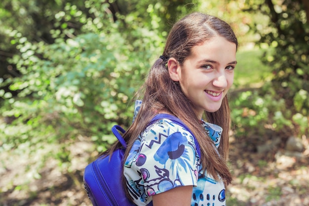 Niña de pie en el parque sonriendo