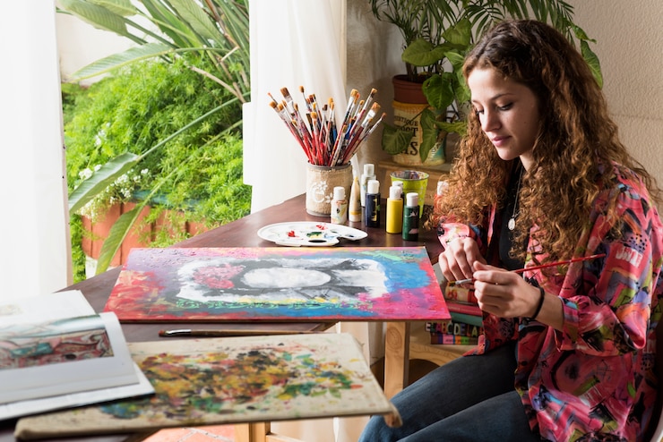 Foto gratuito niña pintando un lienzo en un estudio de arte