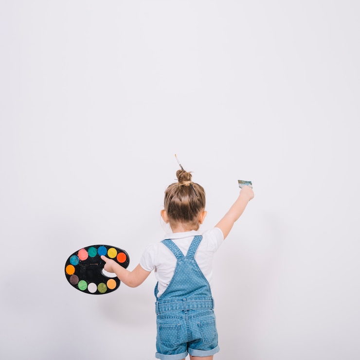 Foto gratuito niña pintando pared blanca con pincel