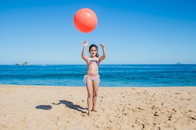 Niña, playa y pelota