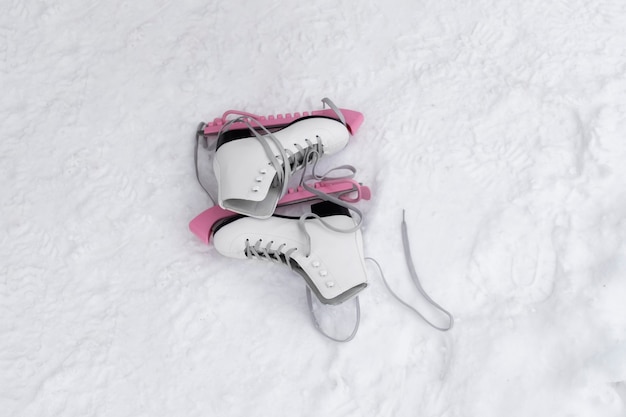 Foto gratuita niña poniéndose sus patines de hielo al aire libre en invierno