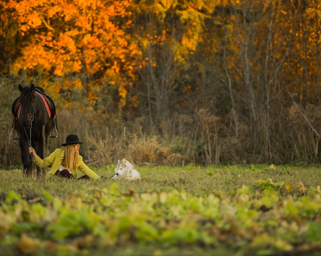 niña posando con un caballo y un perro