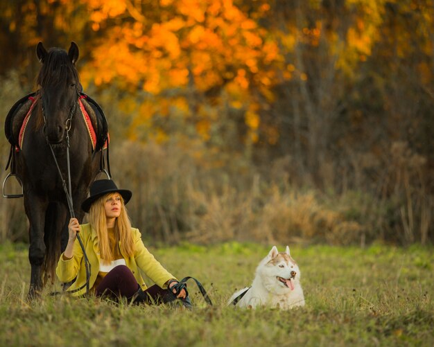 niña posando con un caballo y un perro