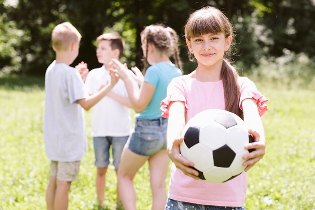 Niña, posar, con, pelota del balompié