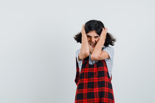 Foto gratuita niña preadolescente agarrando la cabeza con las manos en camiseta