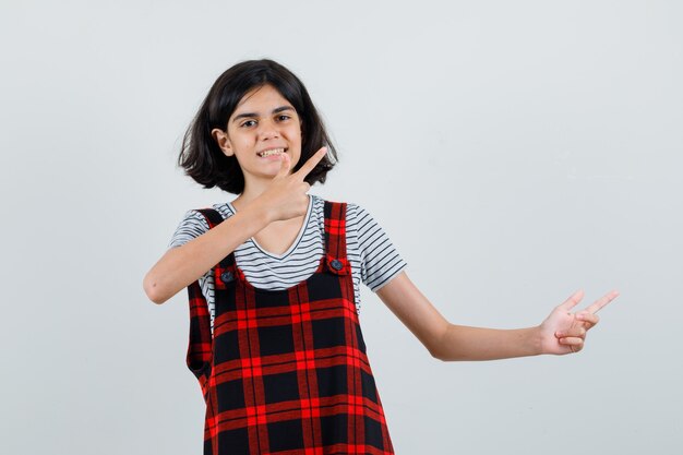 Niña preadolescente mirando a un lado con los dedos en camiseta