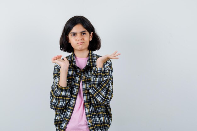 Niña preadolescente mostrando no sé gesto en camisa, vista frontal de la chaqueta.