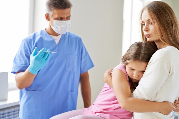 Niña preocupada antes de recibir la inyección