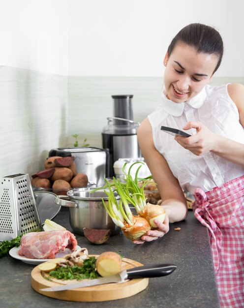 niña prepara comida en la cocina con el teléfono