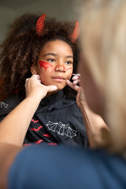 Niña preparándose para halloween con un disfraz de diablo