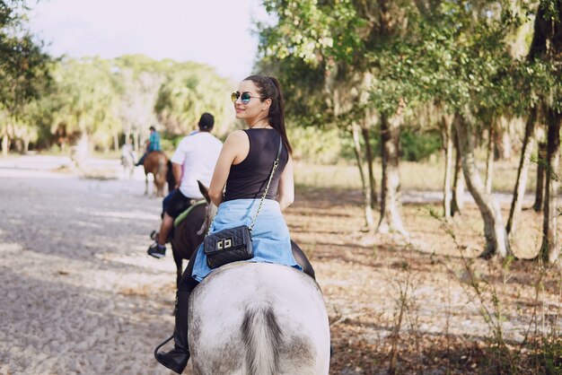 Niña preparándose para montar a caballo