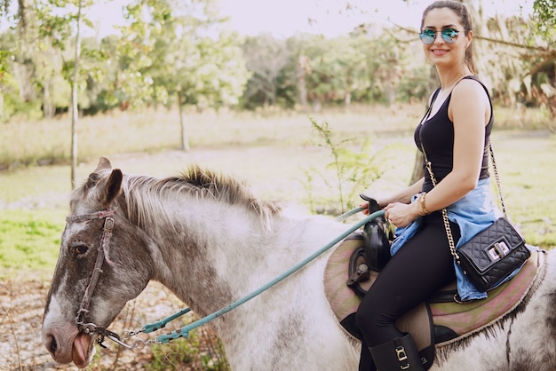 Niña preparándose para montar a caballo