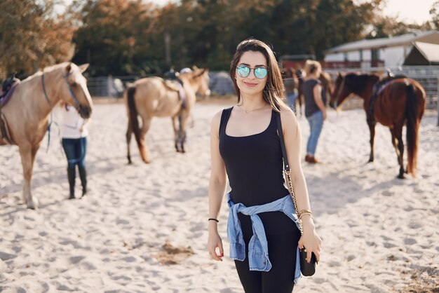 Niña preparándose para montar a caballo