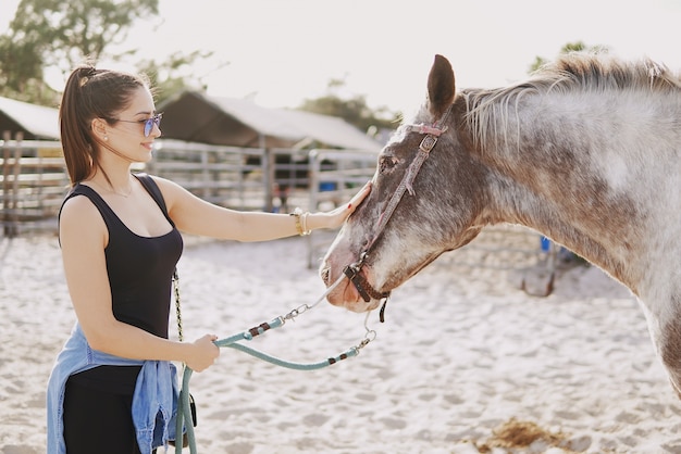 Niña preparándose para montar a caballo