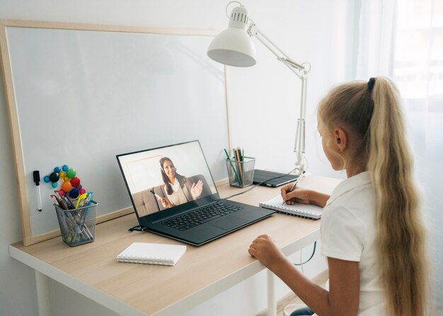 Niña prestando atención a la clase en línea