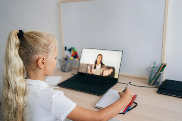 Niña prestando atención a la clase en línea