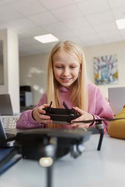 Foto gratuita niña probando un dron y divirtiéndose