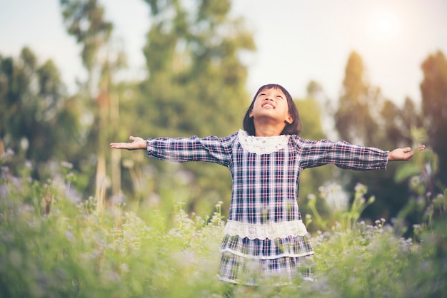 Niña que levanta la mano refresca en el aire