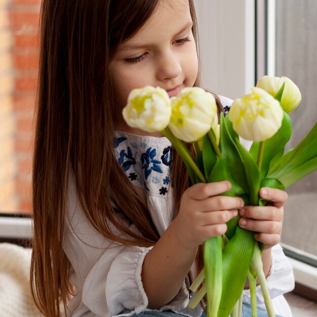 Niña que sostiene las flores