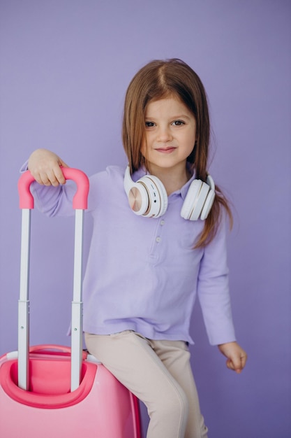 Niña que viaja con maleta de viaje