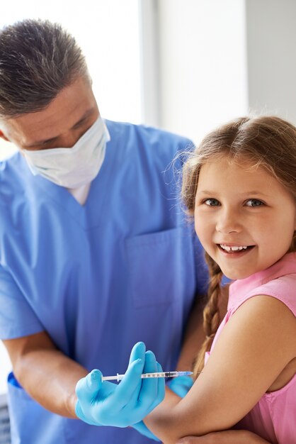 Niña recibiendo una inyección en su brazo