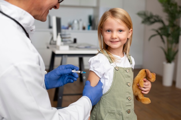 Niña recibiendo una vacuna en el consultorio del médico