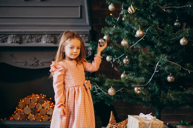 Niña con regalos de arbol de navidad.