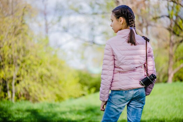 Niña relajada con prismáticos en el parque