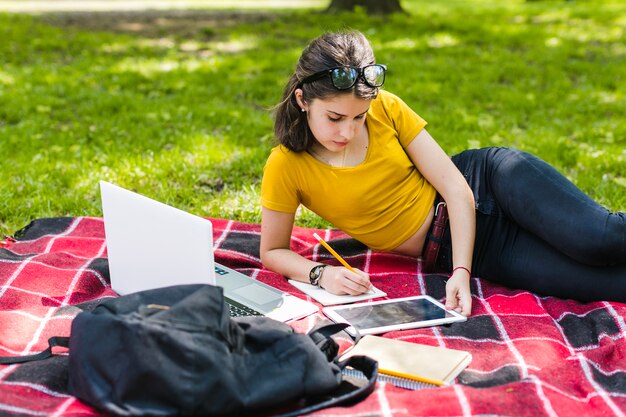 Niña responsable estudiando en el parque