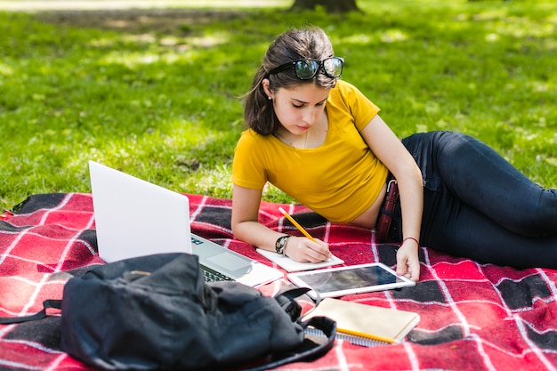 Niña responsable estudiando en el parque