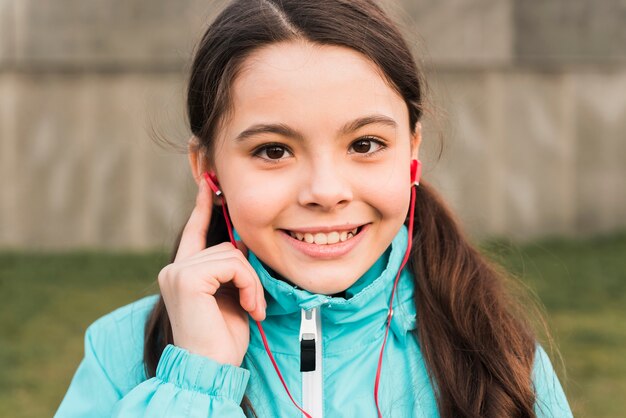 Niña en ropa deportiva escuchando música