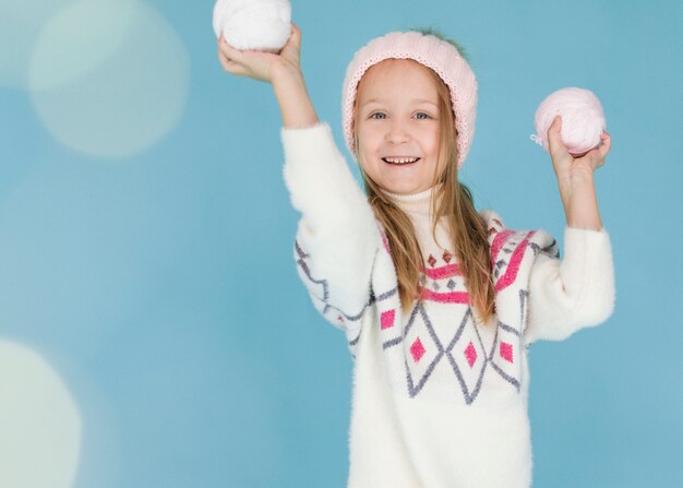 Niña rubia con bolas de nieve